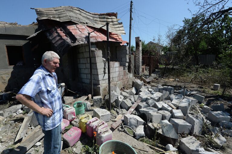 Житель Луганска у дома, разрушенного во время артиллерийского обстрела украинской армией