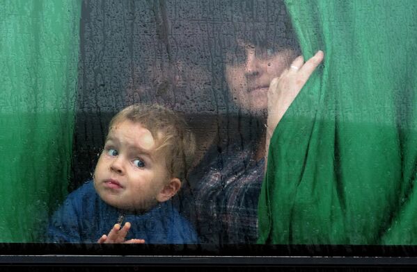 Женщина с ребенком в автобусе с беженцами, который отправляется из Донецка в Россию