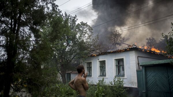 Горящий жилой дом в Луганске после артиллерийского обстрела города