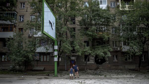 Местные жители у дома, пострадавшего во время артиллерийского обстрела в Луганске.