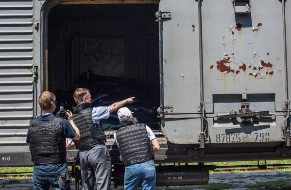 Сотрудники миссии ОБСЕ на станции города Торез осматривают рефрижераторный вагон с телами погибших в авиакатастрофе малайзийского Boeing 777 перед отправкой в Донецк