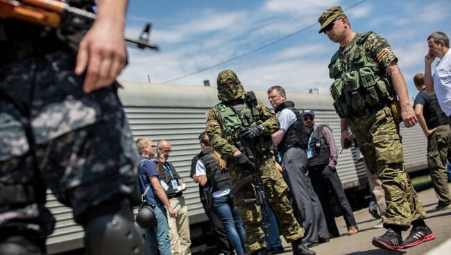 Сотрудники миссии ОБСЕ на станции города Торез перед отправкой в Донецк поезда с пятью рефрижераторными вагонами с телами погибших в авиакатастрофе малайзийского Boeing 777