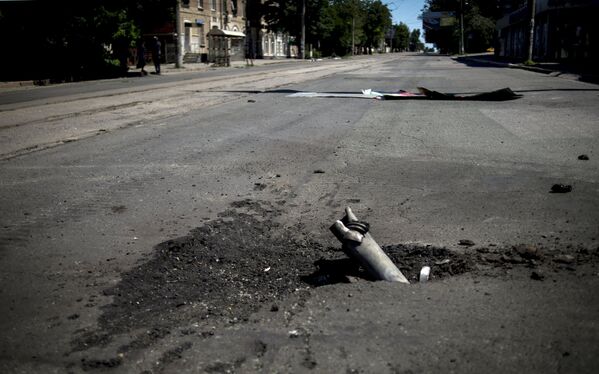 Фрагмент снаряда застрявший в асфальте после артиллерийского обстрела Луганска украинскими силовиками