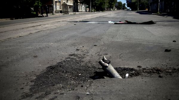 Фрагмент снаряда застрявший в асфальте после артиллерийского обстрела Луганска украинскими силовиками