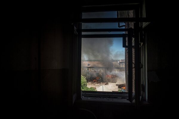 Горящий дом на одной из улиц Луганска, загоревшийся в результате попадания снаряда во время артиллерийского обстрела города украинскими силовиками