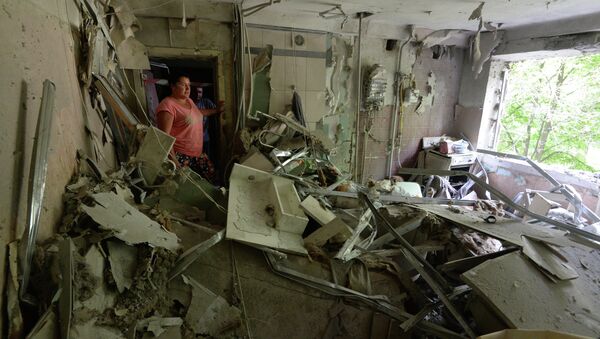 Жители многоквартирного дома на окраине Донецка, пострадавшего от артиллерийского обстрела города украинскими силовиками, в своей разрушенной квартире.