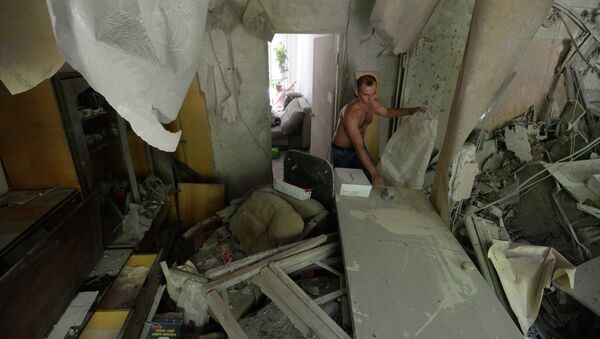 Житель многоквартирного дома на окраине Донецка, пострадавшего от артиллерийского обстрела города украинскими силовиками, в своей разрушенной квартире