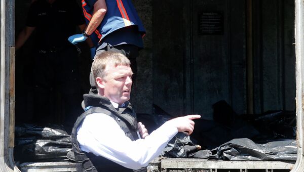 Сотрудник ОБСЕ осматривает тела погибших на вокзале Тореза