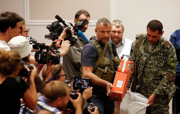 Ополченец ДНР демонстрирует бортовой самописец разбившегося на Украине Boeing 777