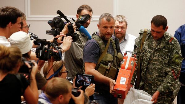 Ополченец ДНР демонстрирует бортовой самописец разбившегося на Украине Boeing 777