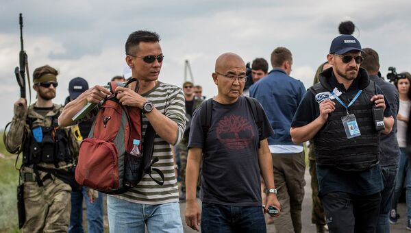 Малайзийские эксперты на месте крушения самолета Boeing 777 авиакомпании Malaysia Airlines на Украине. Архивное фото