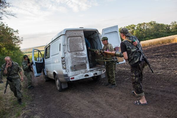 Ополченцы загружают орудие в автомобиль возле города Снежное