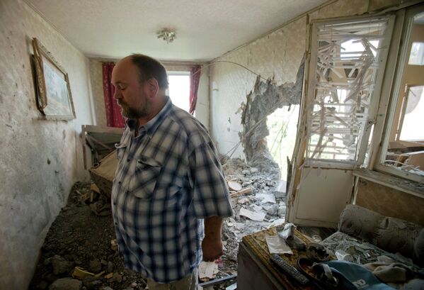 Житель Донецка в разрушенной в результате артиллерийского обстрела квартире