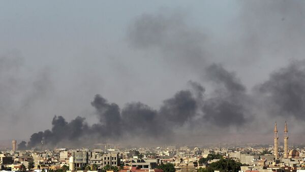 Дым над Бенгази после столкновений с боевиками 26 июля 2014