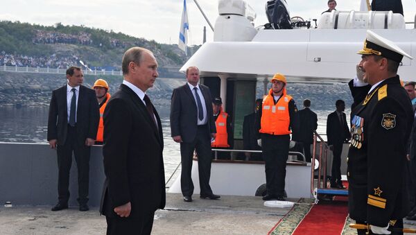 Президент России Владимир Путин (слева) принимает рапорт командующего военно-морского парада в День ВМФ в городе Североморск