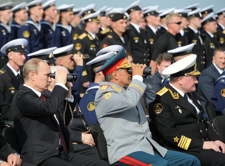 Президент России Владимир Путин (слева) наблюдает за военно-морским театрализованным представлением боевых кораблей Северного флота ВМФ РФ