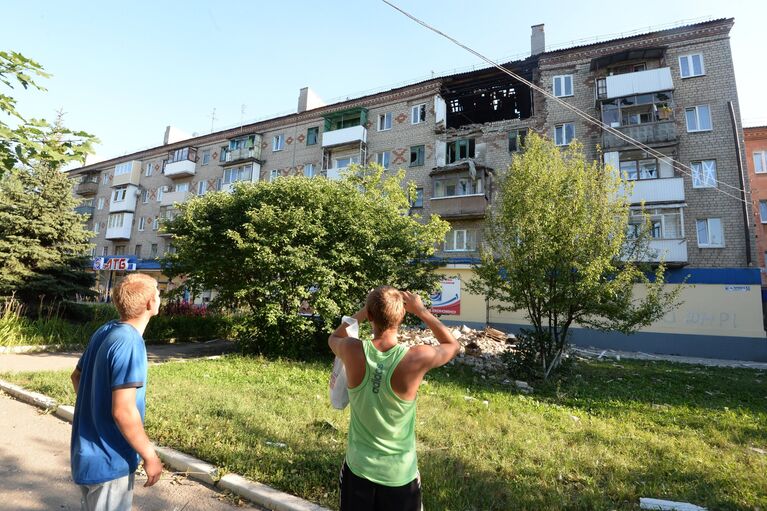 Местные жители у жилого дома, пострадавшего во время ракетно-минометного обстрела Горловки