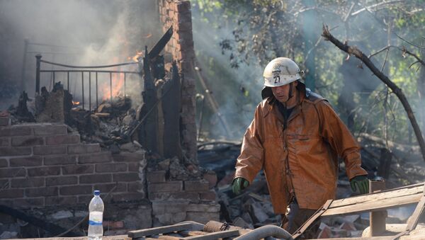 Пожарный работает на месте возгорания в доме, пострадавшем во время  обстрела Горловки. Архивное фото