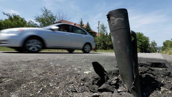 Машина на разбитой снарядами дороге в Донецкой области