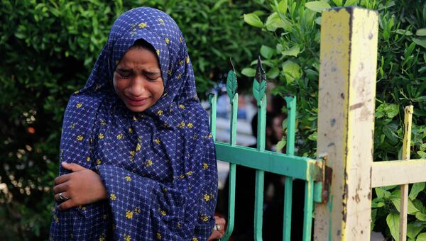 Палестинская девушка оплакивает погибших родных в секторе Газа 30 июля 2014