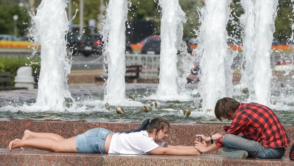 Жители Москвы спасаются от жары у фонтана на Поклонной горе. Архивное фото