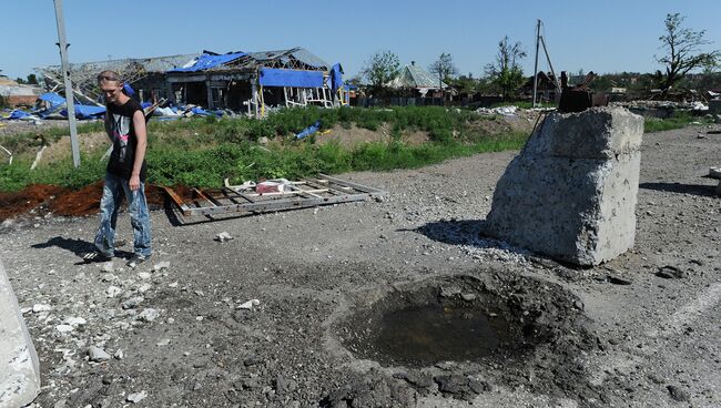 Житель Славянска возле воронки от попадания снаряда