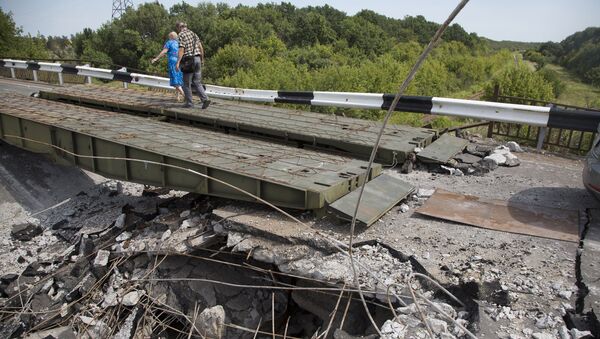 Люди идут мимо разрушенного моста в Дебальцево Донецкой области. Архивное фото