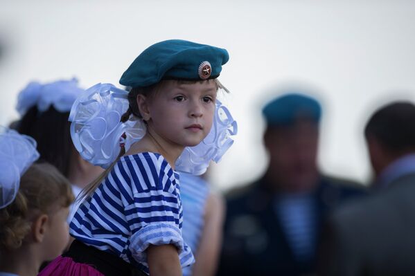 Девочка наблюдает за показательными выступлениями военнослужащих во время празднования Дня Воздушно-десантных войск