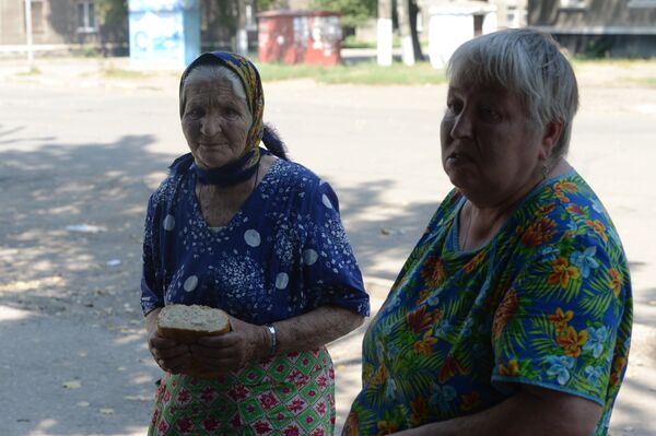 Пожилая женщина держит в руках хлеб, переданный бойцами народного ополчения,в Горловке