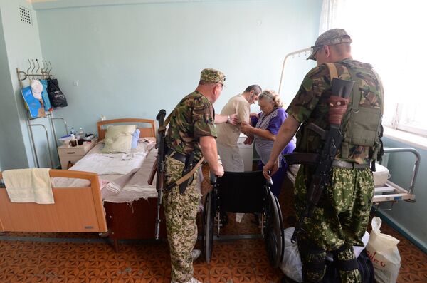 Ополченцы помогают пациенту в городской больнице Горловки