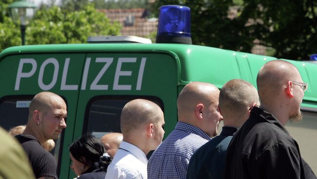 Немецкие неонацисты возле полицейской машины в Германии