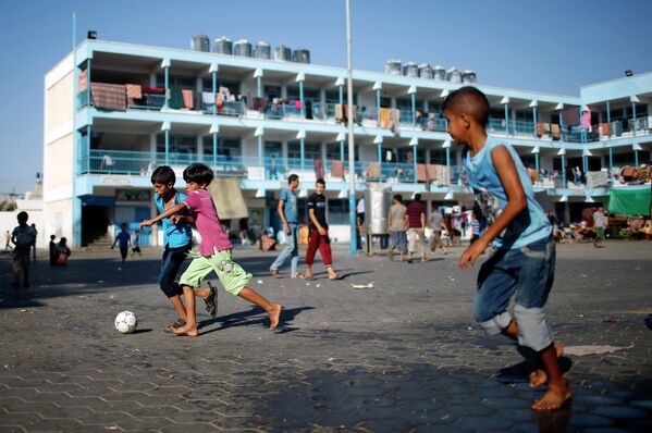 Палестинские мальчики играют в футбол в лагере беженцев в секторе Газа