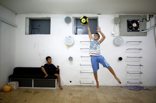 Израильский мальчик играет с мячом в бомбоубежище в городе Ашкелон