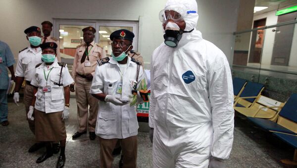 Медицинские работники и сотрудники аэропорта ожидают пассажиров в международном аэропорту в Лагосе, Нигерия
