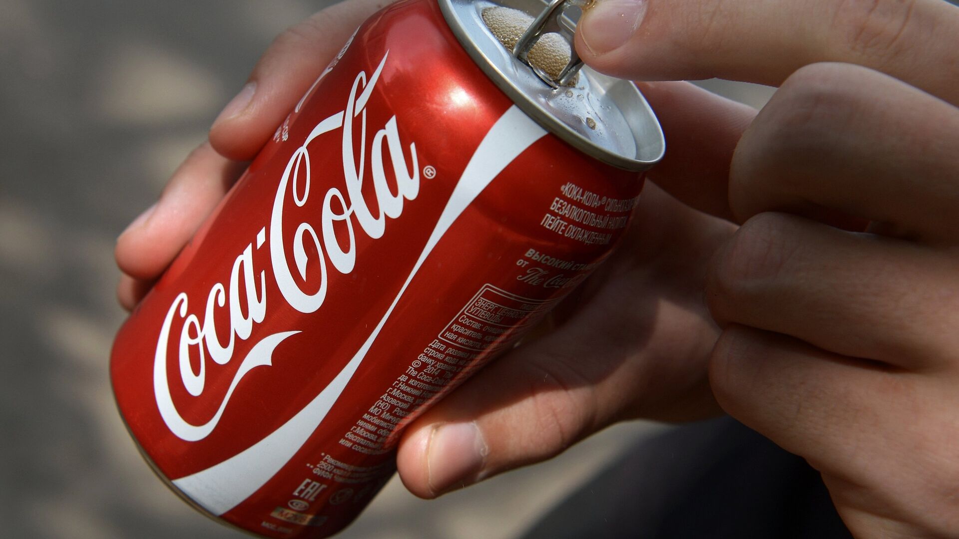 Покупатель держит банку с напитком компании Coca-Cola - РИА Новости, 1920, 16.05.2021