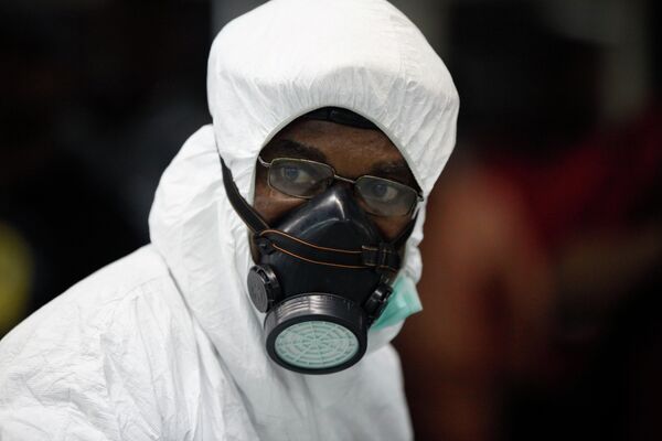 Нигерийский медик в защитном костюме в аэропорту Лагоса, Нигерия