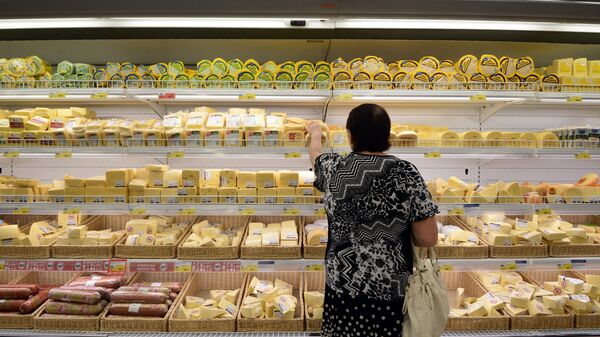 Женщина у прилавка с сырами в гипермаркете. Архивное фото