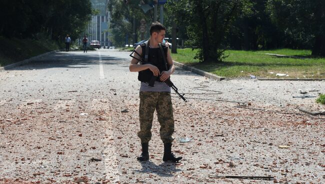 Ополченец около жилого дома в центре Донецка, пострадавшего при артиллерийском обстреле города украинской армией. Архивное фото