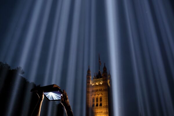 Девушка снимает на планшет световую инсталляцию Спектра в Лондоне, Великобритания