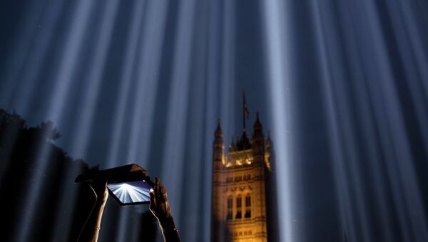 Девушка снимает на планшет световую инсталляцию Спектра в Лондоне, Великобритания. Архивное фото
