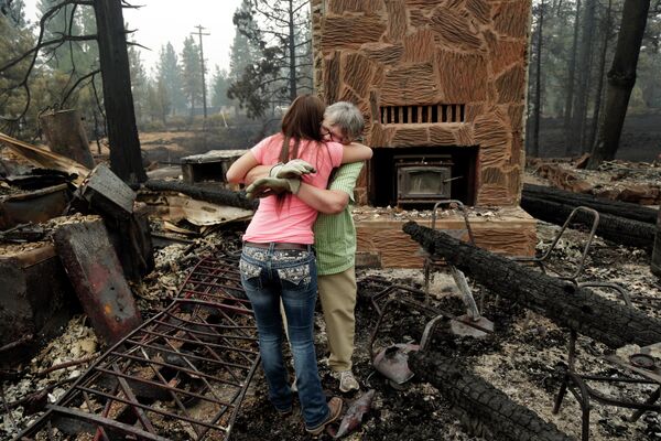 Женщины на месте пожарища в деревне Файрсайд Вилладж, Калифорния