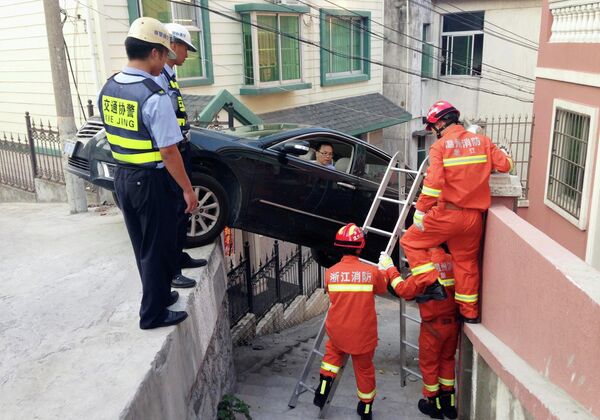 Спасатели помогают водителю застрявшей машины выбраться из нее