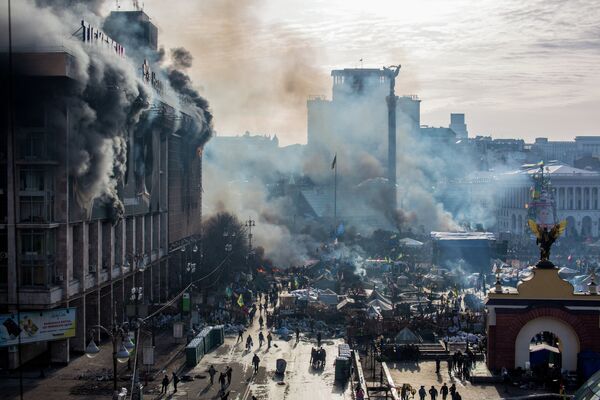 Дым от пожаров и сторонники оппозиции на площади Независимости в Киеве, где начались столкновения митингующих и сотрудников милиции. 2014 год