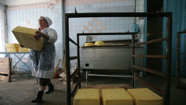 Работница несёт головку сыра. Архивное фото