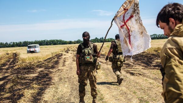 Украинский военный с белым флагом во время передачи убитых на нейтральной территории. Архивное фото