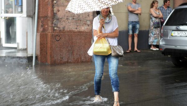 Женщина на Тверской улице во время ливня. Архивное фото