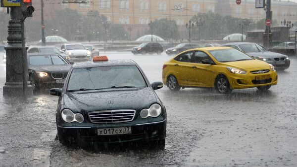 Автомобили на Тверской улице в Москве во время ливня. Архивное фото