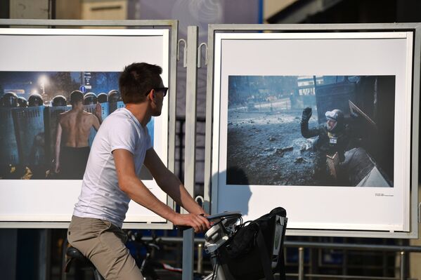 Мужчина смотрит на работы фотокорреспондента Андрея Cтенина