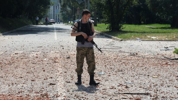 Ополченец около жилого дома в центре Донецка, пострадавшего при артиллерийском обстреле города украинской армией. Архивное фото