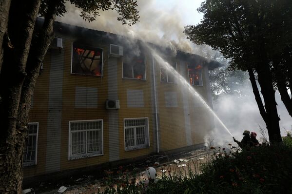 Украинские пожарные потушат огонь в разрушенном здании